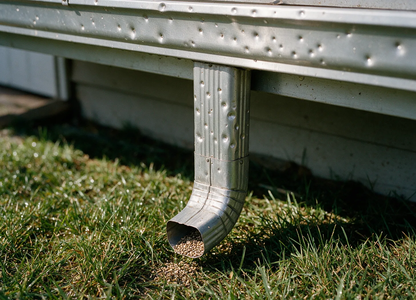 Hail dents in a gutter and downspout